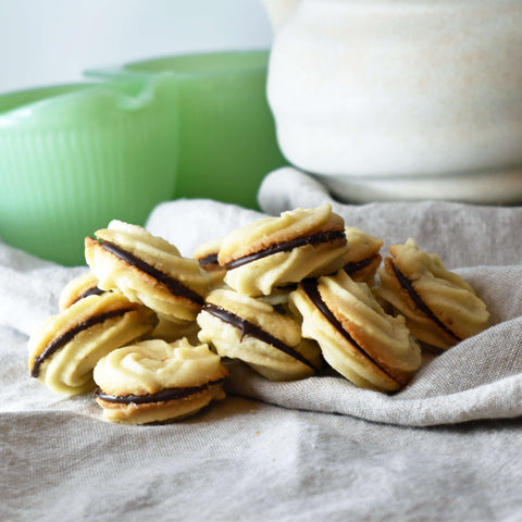 piped butter cookie sandwiches filled with melted chocolate