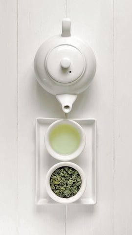 japanese green tea in a cup with a white kyusu teapot from the top