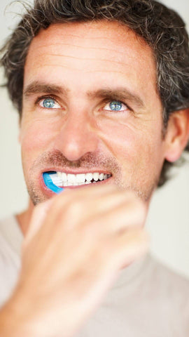man brushing is teeth to avoid stain from green tea