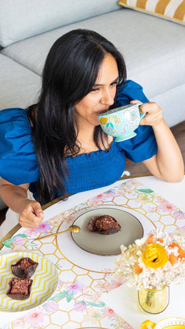 Frau trinkt grünen Tee in einer Küche mit Kalorienrechner