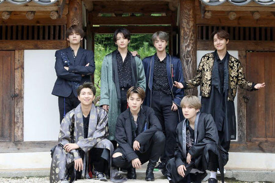 All of the BTS members posing for a picture in modern Hanbok in front of a hanok for the Korean holiday Chuseok.