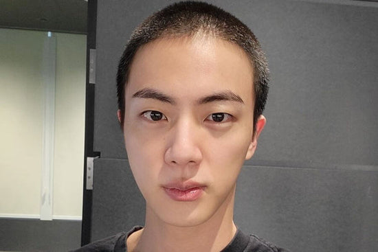 Le membre du BTS Jin avec une tête rasée en préparation de son enrôlement militaire obligatoire en Corée.