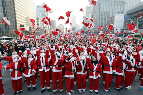 People in the street dressed up as Santa Claus throwing their Santa hats into the air during Christmas in Korea. Picture from ID Hospital blog spot.