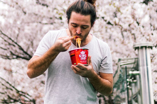 man eating spicy Korean snack noodles