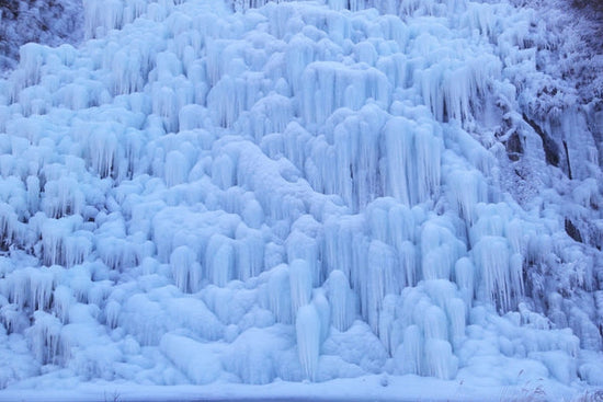 large ice wall formed by frozen waterfall
