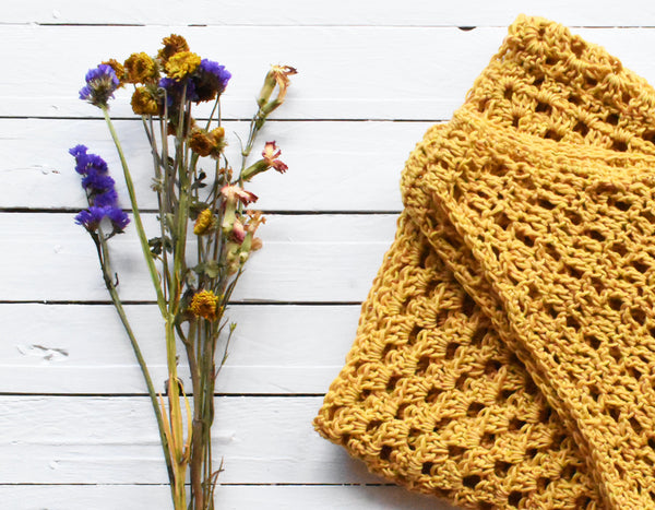 dried flower bouquet next to gold crocheted cloth