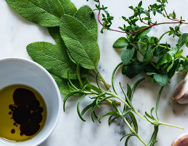 olive oil with fresh sage and rosemary bunches