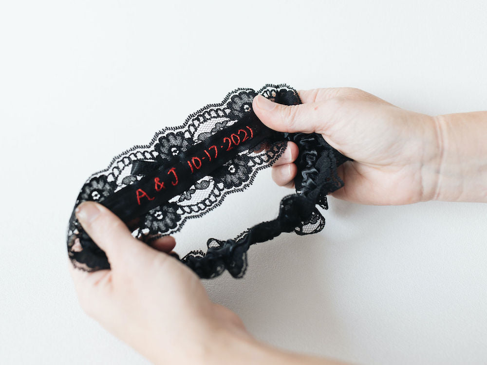 personalized wedding garter with black lace and velvet and custom red embroidery by heirloom designer, The Garter Girl