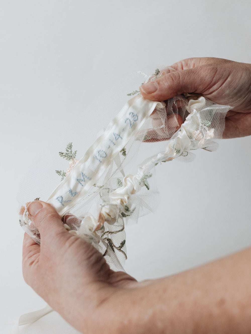 bohemian garter with flowery tulle and an ivory satin bow with embroidery handmade by wedding expert The Garter Girl