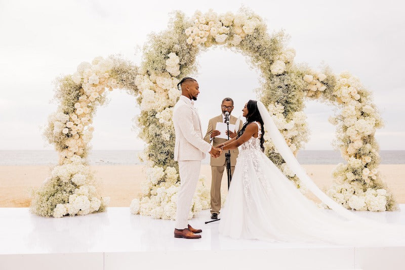 Bride and Groom Exchanging Vows Floral Arches Simone Biles and Jonathan Owens Cabo Wedding