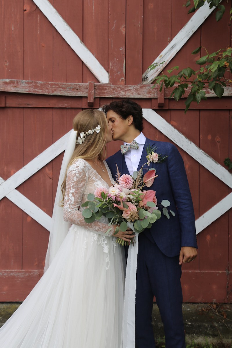 Bride and Groom Share a Kiss at Backyard Wedding Barn Door