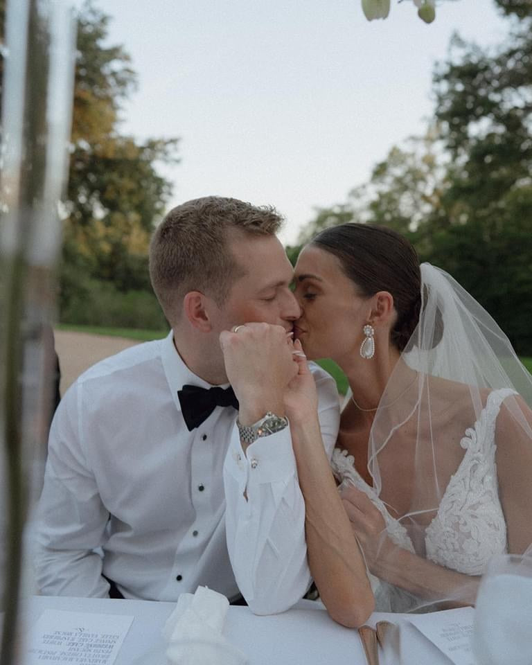 Bride and Groom Share a Kiss at Reception Table