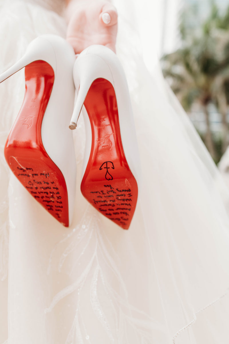 Bride Christian Louboutin Bridal Heels with Message from Groom Written On Red Bottoms