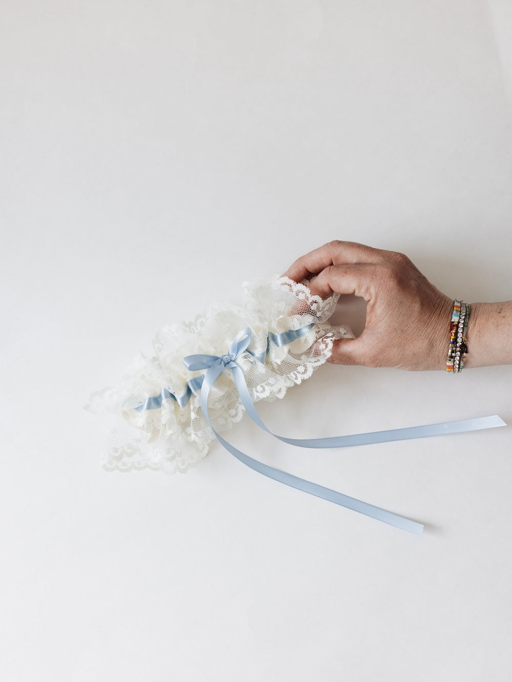 designer ivory lace wedding garter heirloom and light blue satin long-tailed bow handmade by The Garter Girl