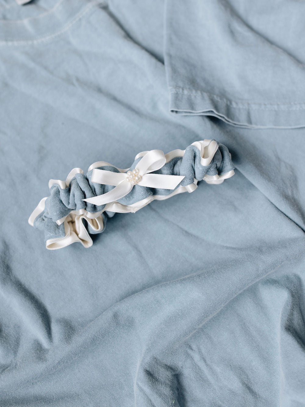 main garter made from ivory tulle and pearls including a blue stripe from dad's t-shirt handmade by The Garter Girl