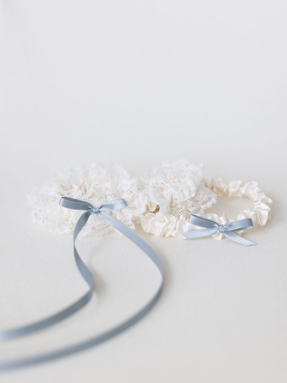 ivory lace wedding garter set with beautiful ivory lace and something blue ribbon detailing handmade by The Garter Girl