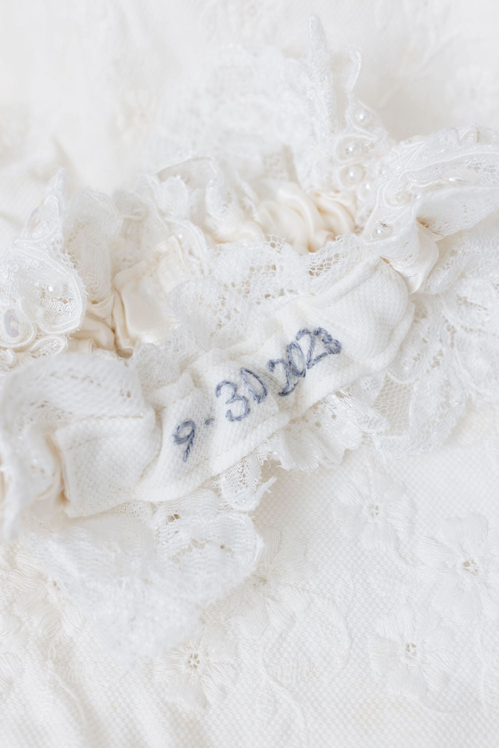 wedding heirloom garter with ivory lace main garter and custom blue embroidery from mom's wedding dress hem handmade by The Garter Girl