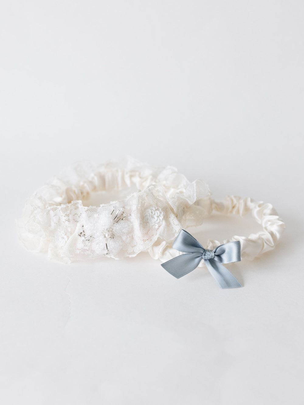 heirloom wedding garter with tulle and pearl materials from mom and grandmother's wedding dress paired with a ivory and blue satin tossing garter handmade by The Garter Girl