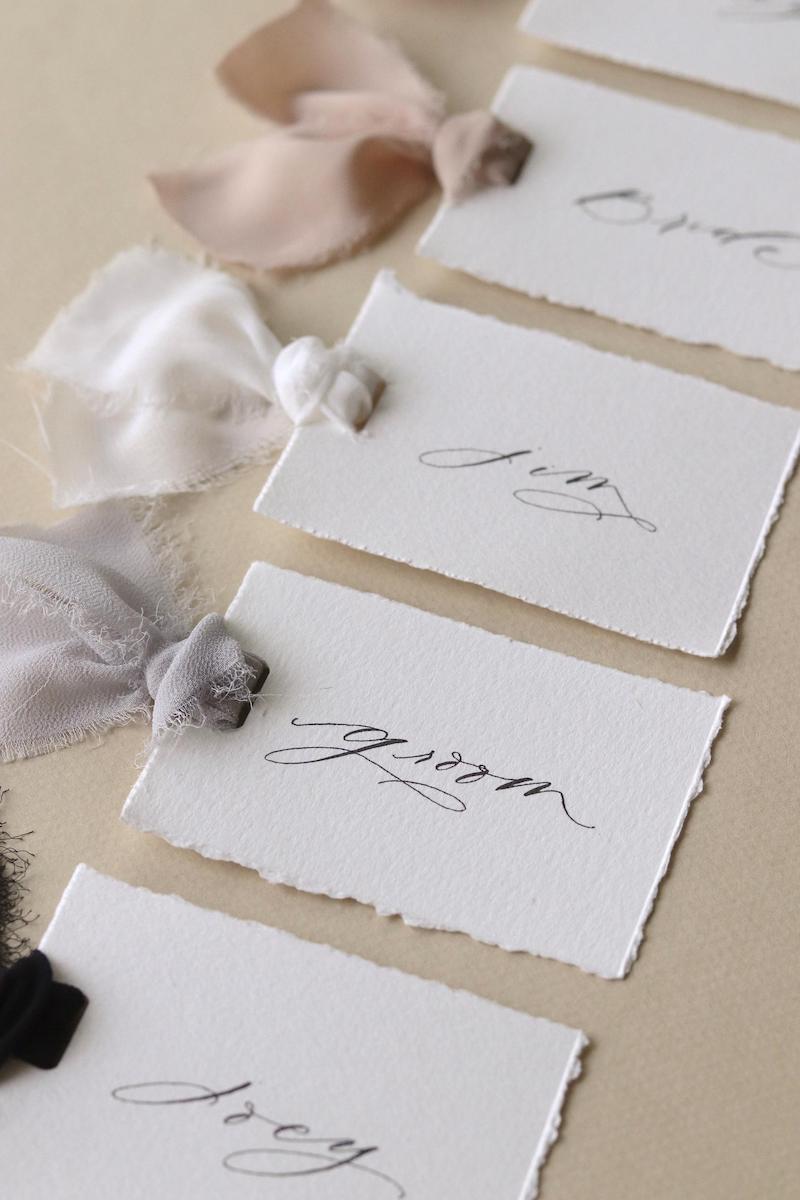 Handwritten White Paper Place Cards with Torn Edges
