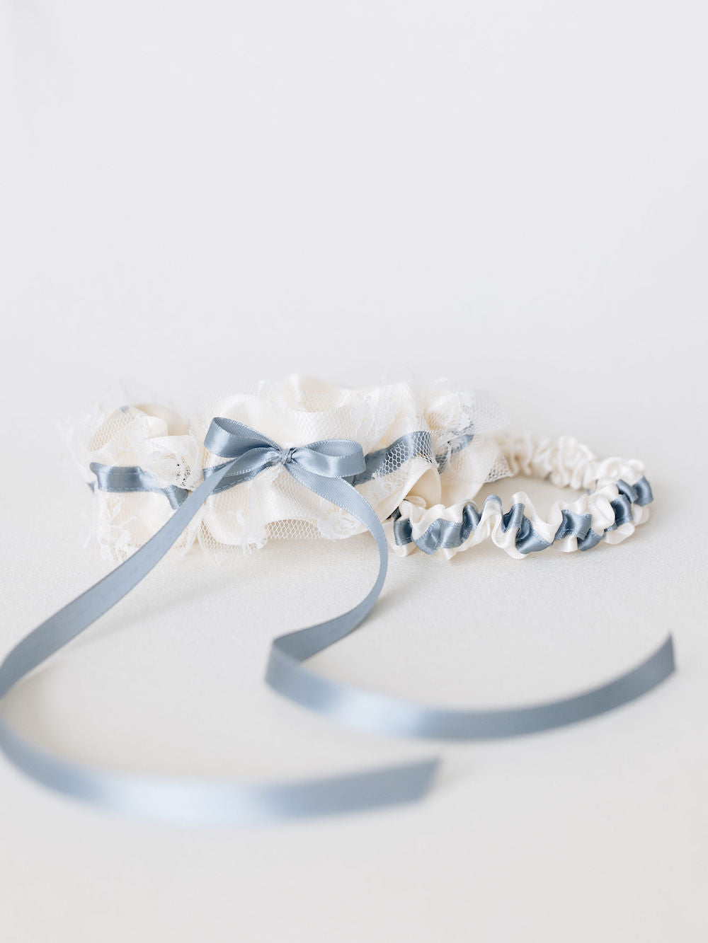 wedding heirloom garter set with something blue ribbon detailing and ivory satin and lace handmade by The Garter Girl