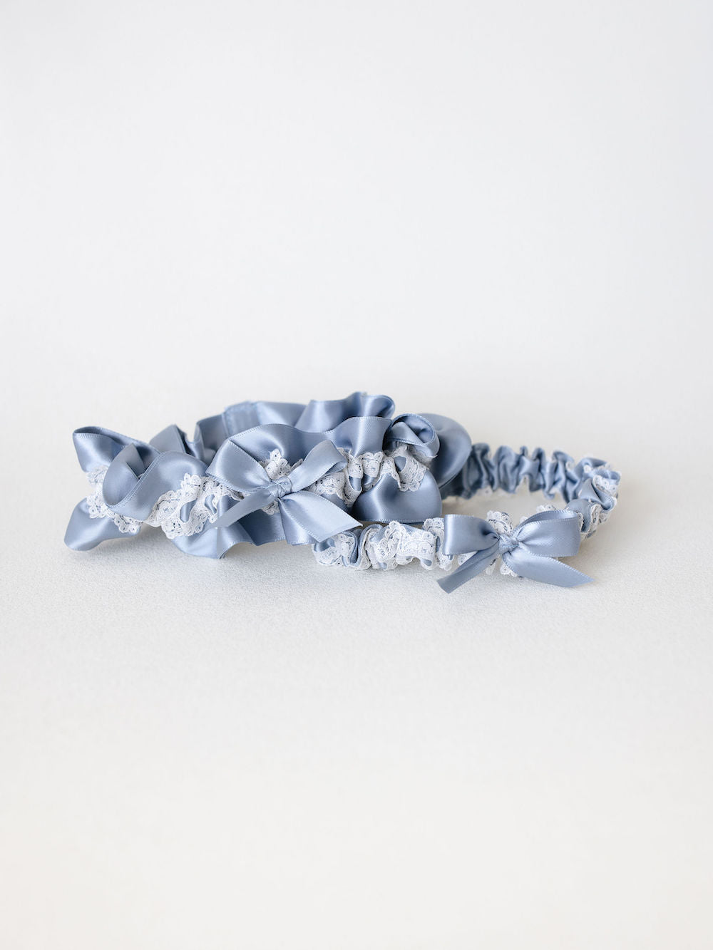garter set in dusty blue satin with main and tossing garter handmade and embroidered by The Garter Girl