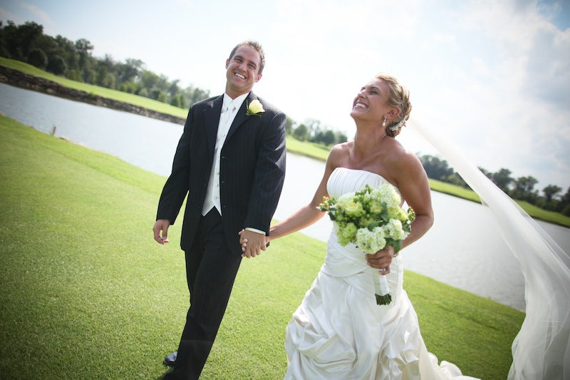 bride and groom walking through golf course
