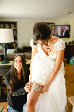 bride-putting-on-wedding-garter-The-Garter-Girl-Kaylee-Casanova-Photography