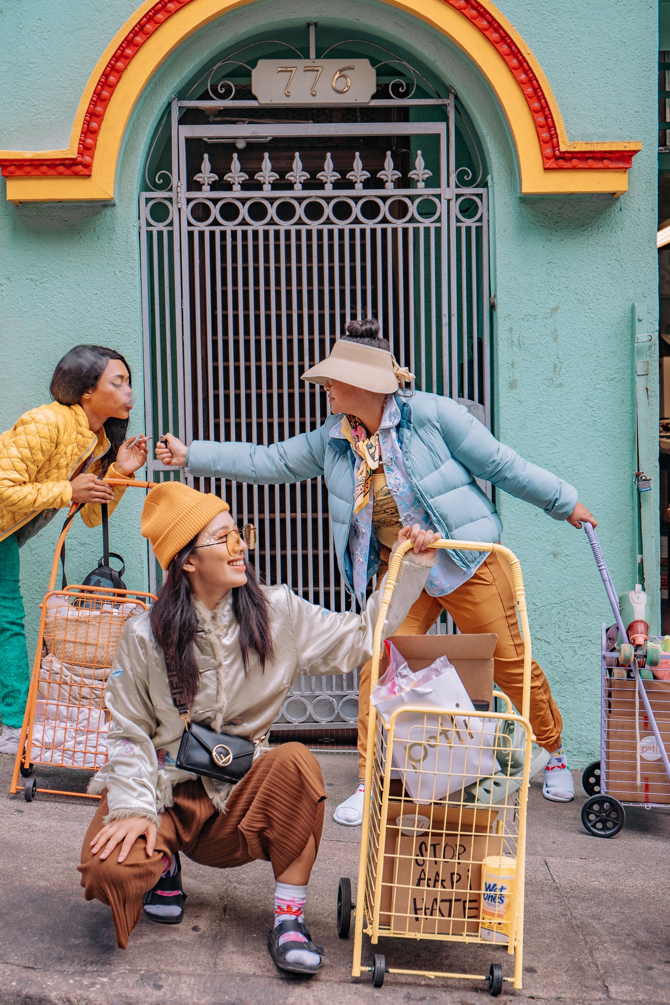Three stylish people with shopping carts in a colorful urban setting.