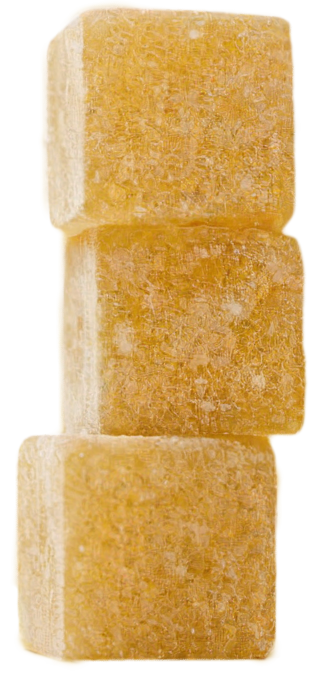 Three brown sugar cubes stacked on a yellow background.