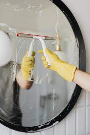 cleaning mirror wearing gloves