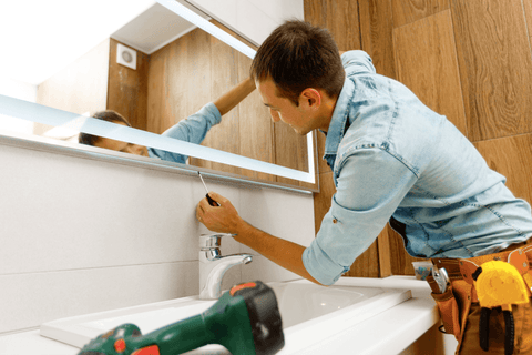 Person installing LED bathroom mirror