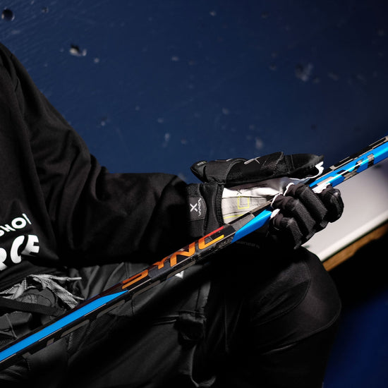 hockey player holding a SYNC stick in the dressing room