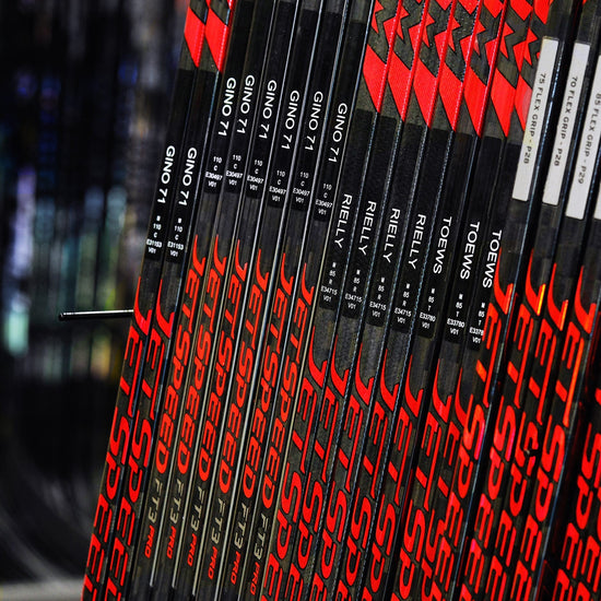 rack of CCM pro stock hockey sticks