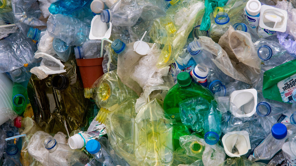 an image of single use plastic bottles and other consumer waste as an example of the impact of plastic pollution