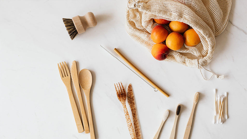 a selection of sustainable plastic free products including bamboo cutlery and reusable grocery bag