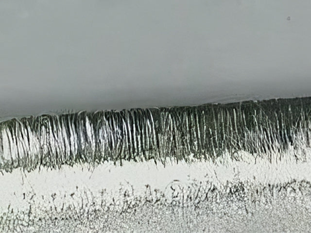 Close up of a Global knife edge under a microscope