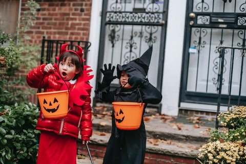 a boy and a girl in Halloween costumes are excited about Halloween gift ideas