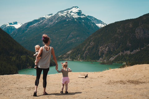 A mom and her two kids enjoying a lake view.