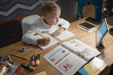 Boy doing his homework in parts as an example of teaching kids time management skills