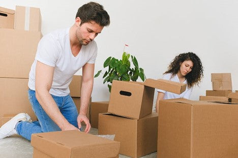 Man and woman packing cardboard boxes