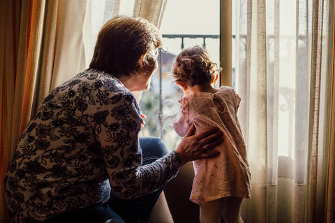 A woman and her granddaughter are looking out the window.