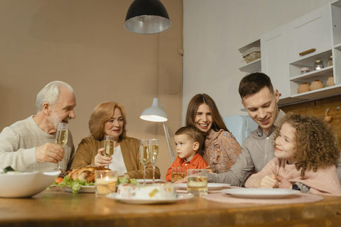 A family having a meal together and discussing the role of grandparents in a child's early development and learning.