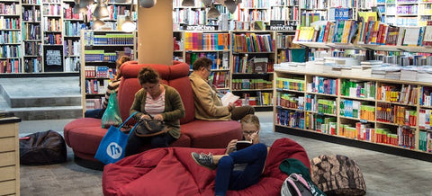 people and kids reading in a dedicated area in the library