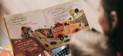 A mother reading to a toddler and encouraging early literacy