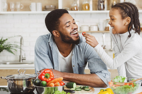 Child feeding dad a tomato