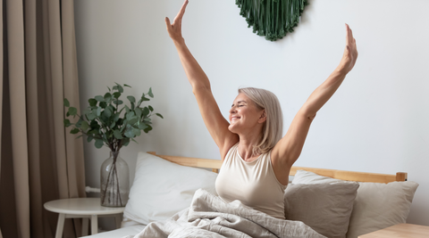 woman stretching in bed no longer suffering with arthritis pain