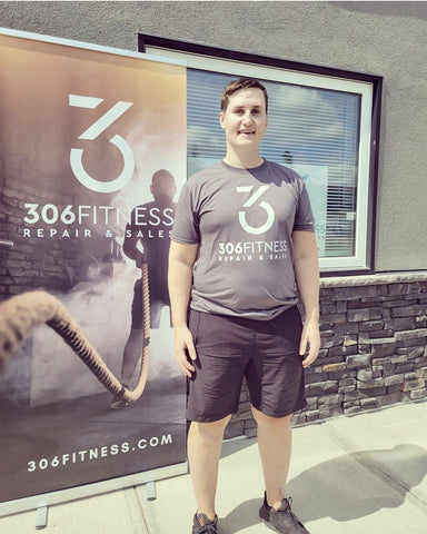 Shane Ashby stands in front of 306 Fitness building with a smile