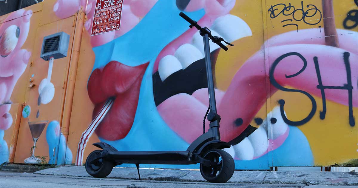 Electric scooter with custom paintwork stands out by colorful street mural, embracing the spirit of DIY creativity.