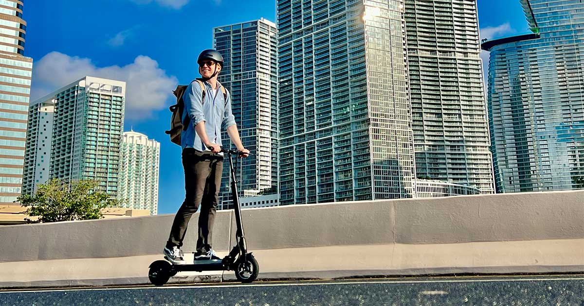 Electric scooter user navigating through city streets with skyscrapers