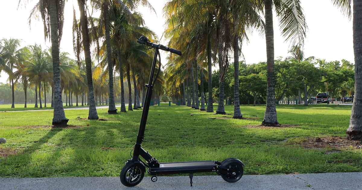 A modern black electric scooter stands on a sunlit boulevard lined with palm trees, epitomizing the eco-friendly transport revolution.